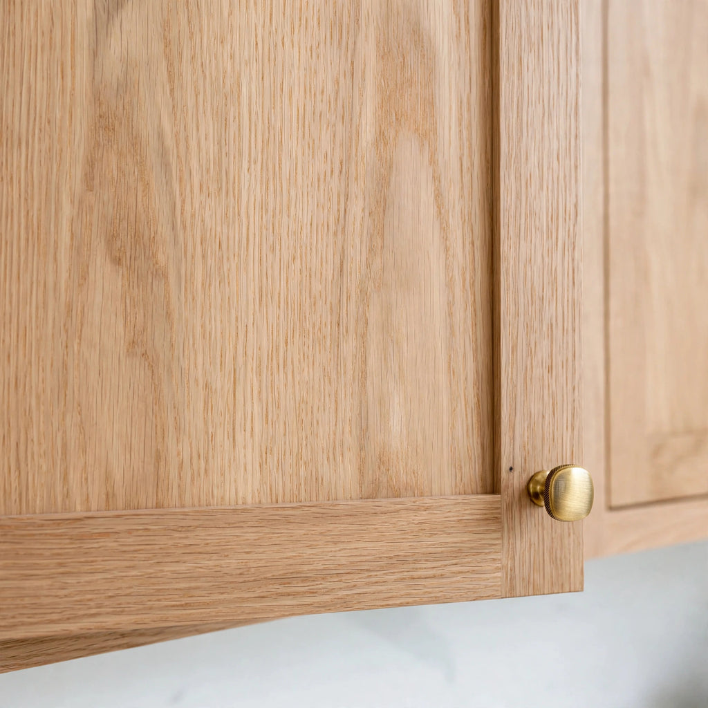 Close-up of slim shaker cabinet door in White Oak with brass knob